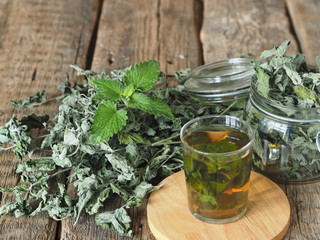Drug plants.Herbal tea with dried Melissa or mint on a natural wooden table.
