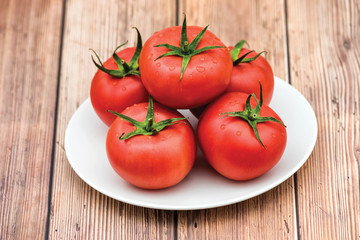 Raw ripe pink heirloom organic tomatoes on wooden background. Vegetarian - Vegan healthy diet culinary cooking concept