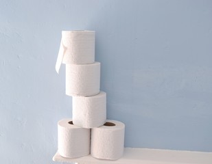 Toilet paper rolls stack on blue background.