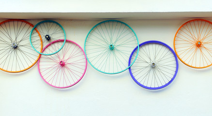 Oude fietswielen kleurrijk aan de muur van een verhuur- en reparatiewerkplaats, hipster decoratief trendconcept