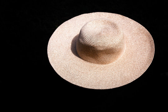 Imagen de un sombrero de playa elegante sobre fondo negro ideal para verano