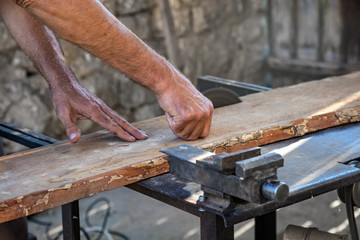 Carpenter using vintage electric circular saw.