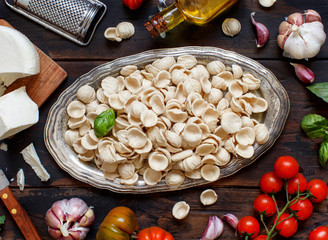 Fresh raw  italian pasta orecchiette, vegetables, herbs and olive oil