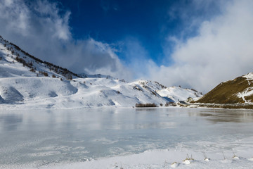 Fototapeta na wymiar Lago ghiacciato al confine tra Italia e Francia al Colle della Maddalena