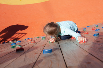 the child climbs the wall for climbing. Children rock climber at the playground