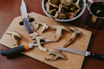 Mushrooms and knives. Cut mushrooms and knives are on  board