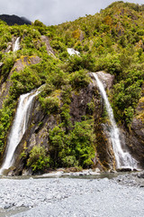 Fototapeta na wymiar Small double waterfall near Franz Joseph Glacier. New Zealand