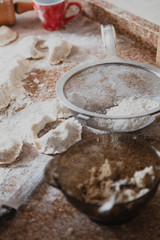 Raw dumplings and round sieve lie on table