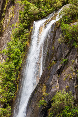 Fototapeta na wymiar High waterfall near Franz Joseph Glacier. New Zealand