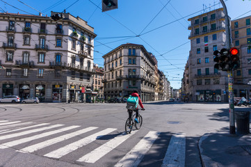 Milan, Italy - APRIL 29, 2020: view of Largo D'Ancona with rider during the coronavirus pandemic lockdown