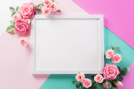 Happy Mother's Day, Women's Day or Valentine's Day greeting concept. Pastel Colours Background with picture frame and pink reses flowers flat lay patterns.