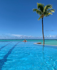 Woman Bathing in Infinity Pool Looking Out to Sea