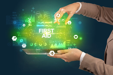 Close-up of a touchscreen with FIRST AID inscription, medical concept