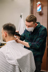 Male hairdresser barber shop concept with medical mask