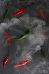 Chilli pepper levitate on concrete background with smoke. Many hot peppers.