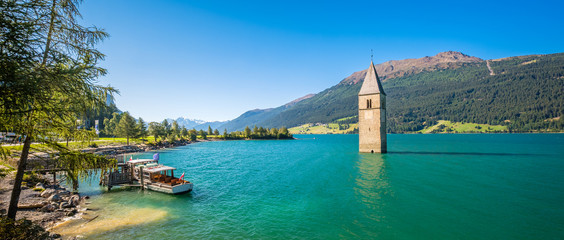 Lake Resia (Reschensee) and Ortler Mountains in Val Venosta (Alto Adige, Italy). It is famous for the tower of a 14th-century church of village Graun that submerged when the lake was deepened in 1950