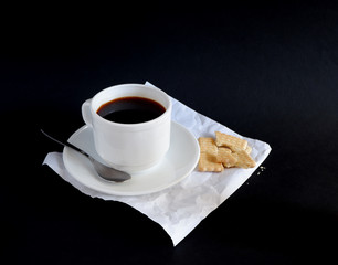 A Cup of black coffee and cookies on a black background. Suitable for mockups and advertising backgrounds
