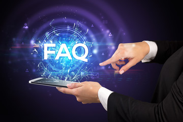 Close-up of a touchscreen with FAQ abbreviation, modern technology concept