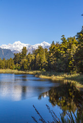 Mountains are reflected in the lake. Matheson lake, New Zealand