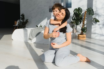 funny mom and son on the floor in the living room, concept motherhood and emotions