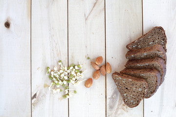 Healthy food, bread, nuts and sprouted mung bean spread out on a wooden eco background