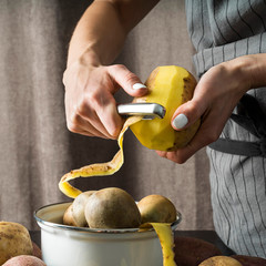 Woman peeling a raw potato