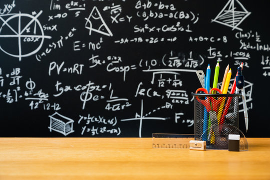 Education background concept. Stationery in holder color pencil, compasses tool, scissors, rulers, sharpener On chalkboard with the Mathematical formula background.