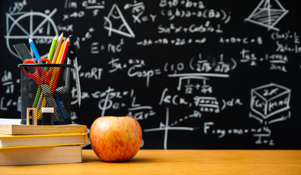 Education background concept. Stationery in holder color pencil, compasses tool, scissors, rulers, sharpener with apple On chalkboard with the Mathematical formula. - Powered by Adobe
