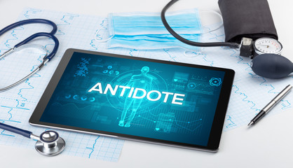 Tablet pc and doctor tools with ANTIDOTE inscription, coronavirus concept
