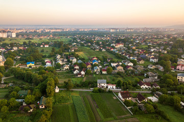 Aerial landscape of small town or village with rows of residential homes and green trees.