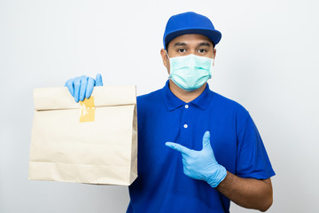 Fototapeta na wymiar Delivery man blue uniform wearing rubber gloves and mask holding paper bag on white background.