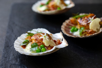 Scallops with cauliflower puree, pancetta, green peas and micro herbs