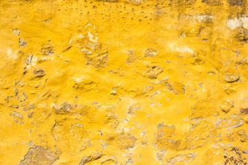 Close up view of yellow wall falling apart
