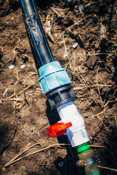 Plastic Valve On A Garden Hose With A Red Handle For Watering