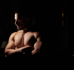 muscular young man in the dark, portrait of a young man in the dark