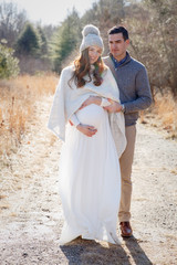 Pregnant couple ourdoors in a natural setting. 