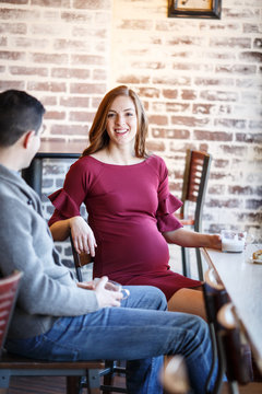 Pregnant couple in a cafe setting
