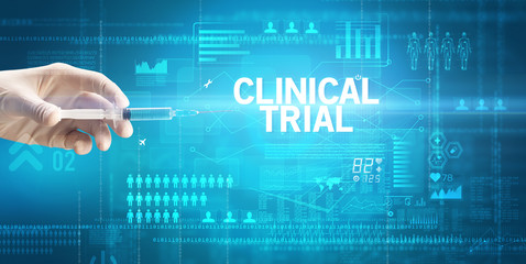 Close-up view of doctor's hand in a white glove holding syringe with CLINICAL TRIAL inscription, healthcare and medical concept