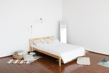 The interior of the bedroom. A spacious, bright, fresh bedroom with white walls and wooden floor,...