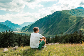 Naklejka na ściany i meble Man use smart phone to talk in mountains. The beautiful landscape of mountains hill in summer. Communication concept
