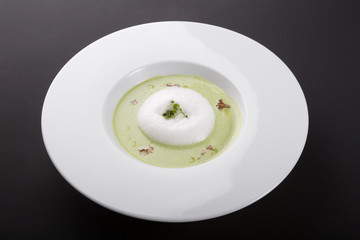 Green cream soup in white bowl
