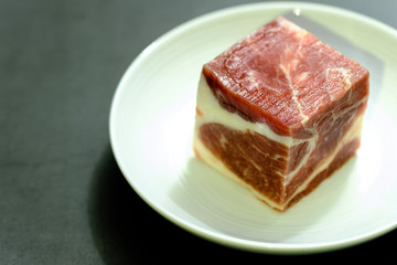 Fresh raw beef cubes isolated on white plate view