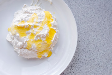 sweet dessert - on a white plate white mass of white color topped with yellow, sweets for any age