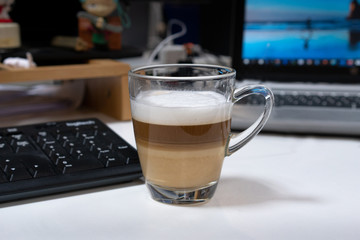 A cup of coffee with milk on the table in office