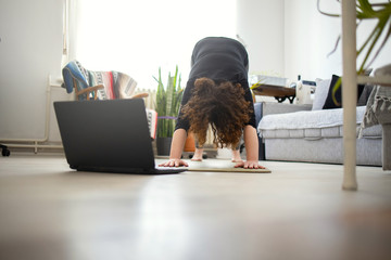 Young woman practicing yoga at home