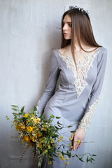 Portrait of beautiful bride. Wedding dress. Wedding decoration. Luxury hairstyle with diadem and bouquet of flowers