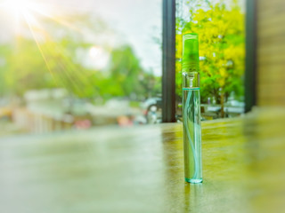 Alcohol spray small for cleaning hands or objects around, soft sunlight background.