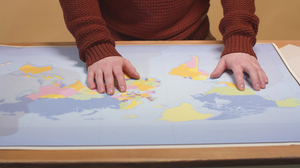 A man opens a map and pointing on it. Close up