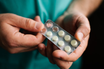 Doctor holding pack of pills in hands 