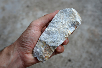 A sedimentary Chert rock in the hand. Chert is a hard, fine-grained sedimentary rock composed of...